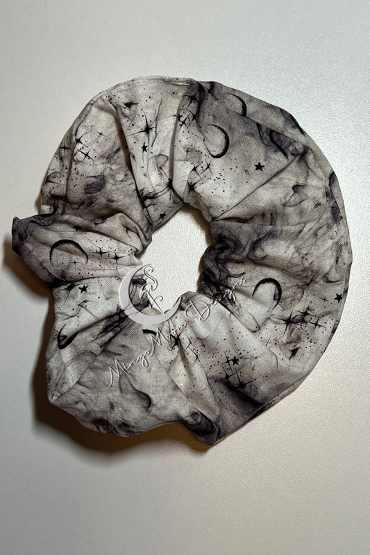 White fabric  with black stars and moons with a dusty smokey look Scrunchie