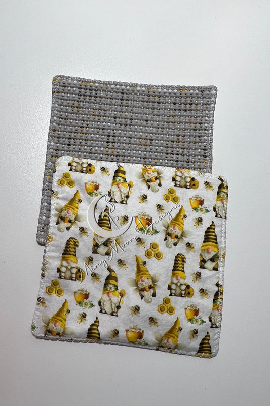 White fabric with gnomes, bees and honey with a slip grip back jar opener