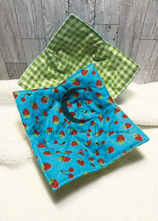 Blue fabric with red strawberries and cherries reverse side is green and white plaid