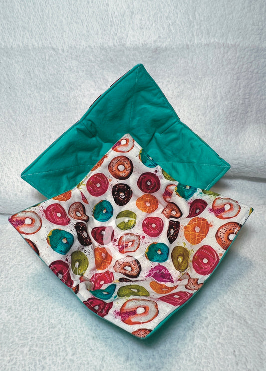 White fabric with multicolored donuts with a aqua green backing.